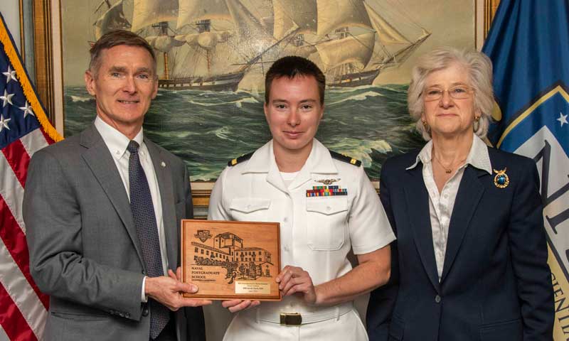 U.S. Navy Ensign Sarah Clark, middle, is recognized for her win in the 2022 NPS Foundation/U.S. Naval Institute (USNI) Annual Essay Contest by USNI Proceedings Editor-in-Chief retired Navy Capt. Bill Hamblet, left, and NPS President retired Vice Adm. Ann E. Rondeau. Clark's essay, 