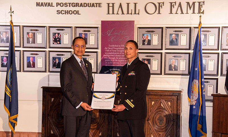 Retired U.S. Navy Adm. Cecil Haney, left, is welcomed into the NPS Hall of Fame by current NPS student U.S. Navy Lt. Dishan Romine.